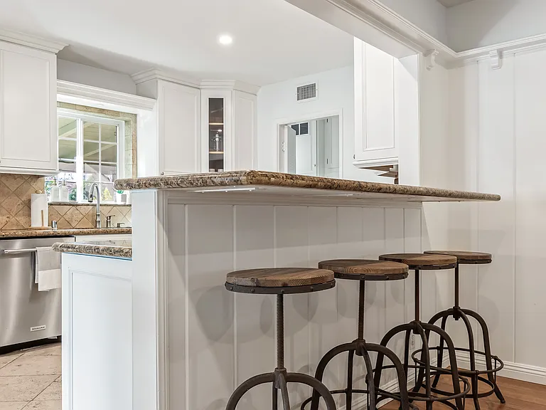Fully stocked kitchen with abundant natural light, backyard views, bar seating, and a convenient work station for everyday living.