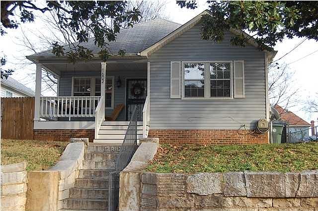 Cute front porch, historic stone wall at street