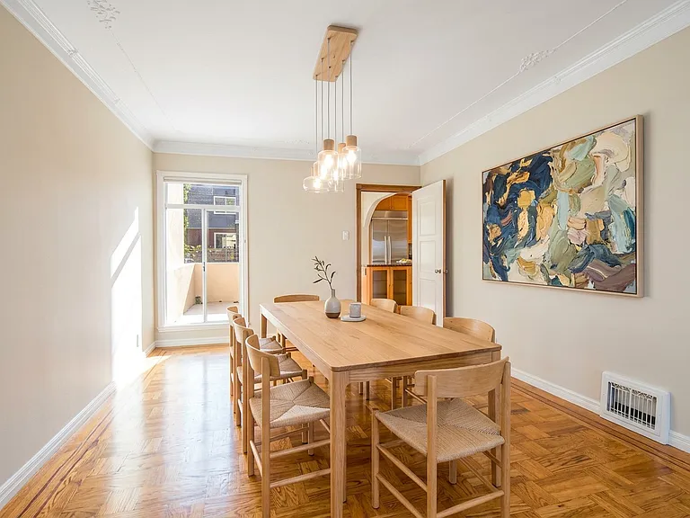 Large Formal Dining room on main level, can comfortably seat up to 12. Main level patio/deck seen in back left, styled with ai.