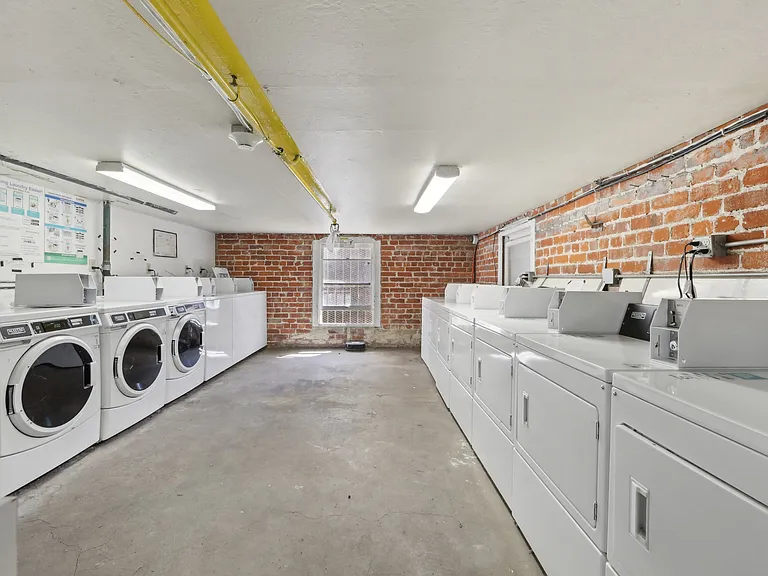 Well-lit laundry room with washing machines and dryers