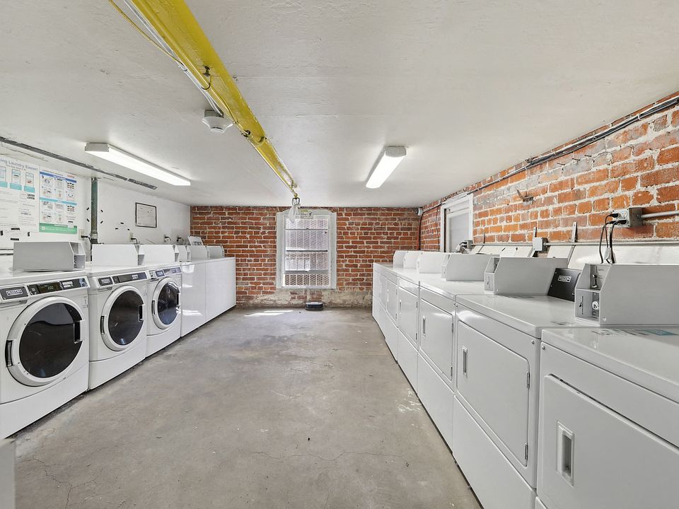 Well-lit laundry room with washing machines and dryers