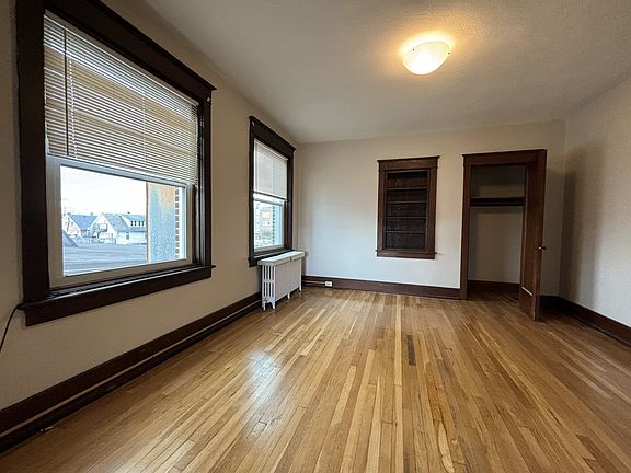 Another view of the living room, featuring a built in book shelf and closet