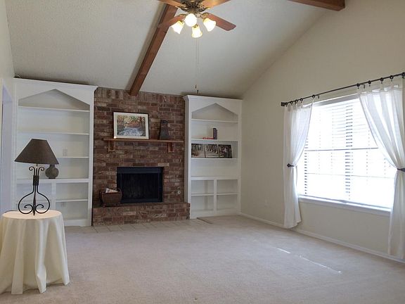 Large living area with fire place, bookshelves and vaulted c