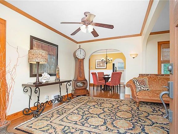 LIVING ROOM with its charming arched doorways, exposed gleaming hardwoods, crown molding, custom painted walls.  Welcome.
