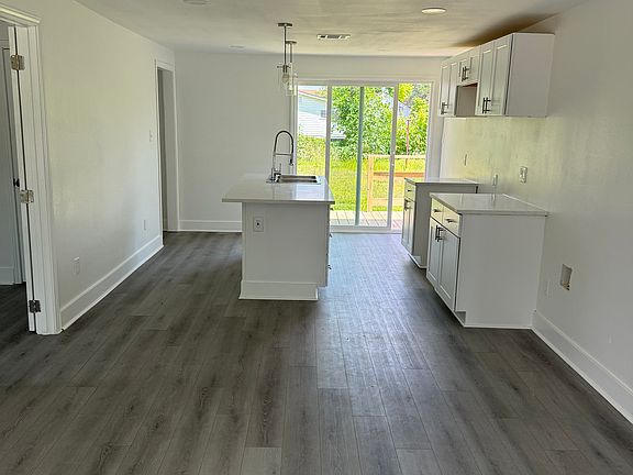 open layout, natural light, recessed lighting, pendant lights at island bar