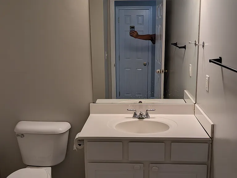 Clean, spacious bathroom vanity with bright 4-light fixture and large mirror