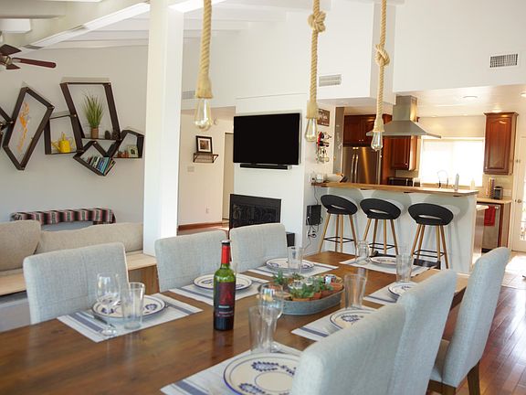 View from the dining table towards open living room, breakfast bar and kitchen.