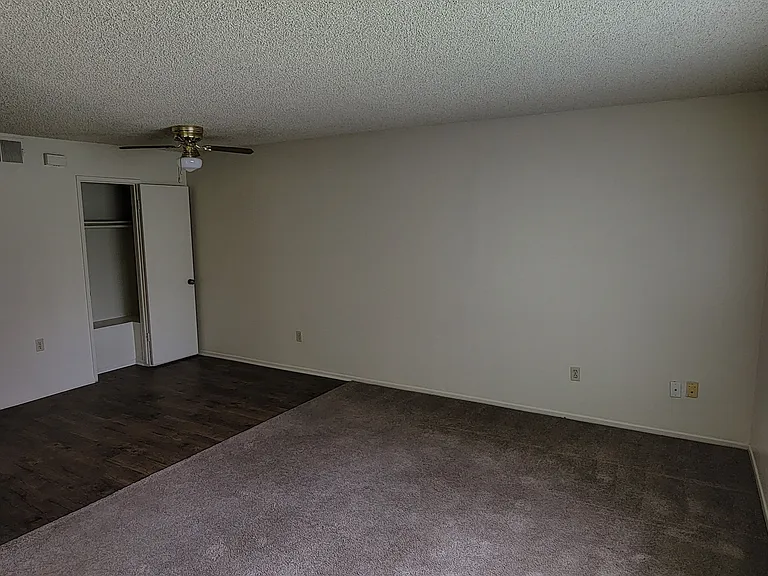 Living room and dining room area with large front window at Magnolia Apartments in Riverside, California.