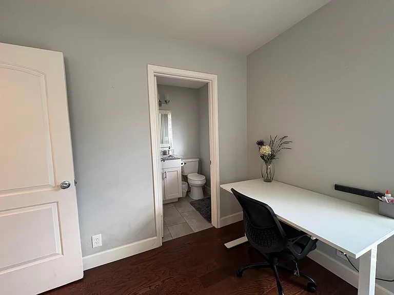 Primary suite has a half-bath attached and space to work with a stand-up desk for working.
