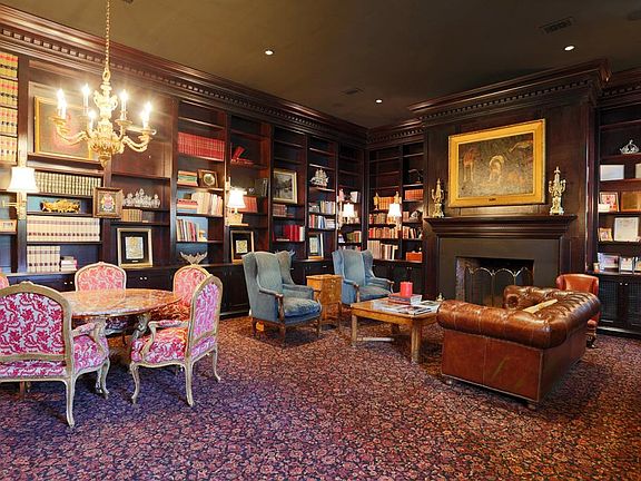 The Library (19x22) contains floor-to-ceiling ratchet-shelf bookshelves, a wood burning fireplace an