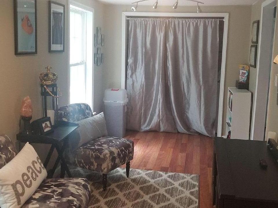 Entry way sitting area. Laundry behind curtain