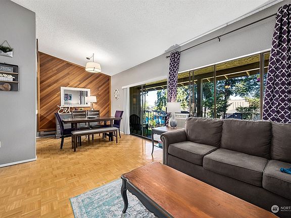 A wall of sliding glass doors flood this space with natural light.>