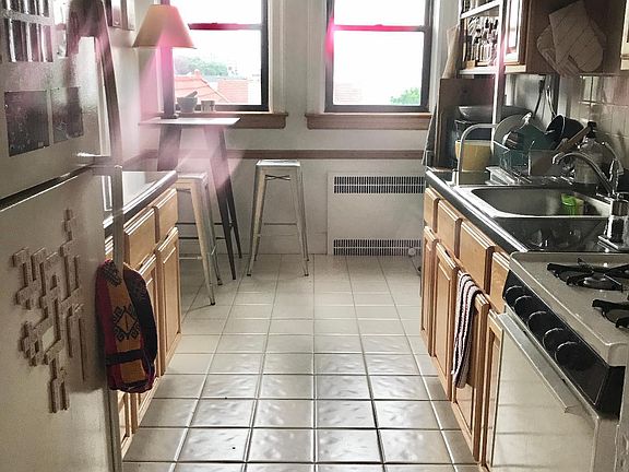 Galley kitchen with a dining area with 2 windows that have views of the Hudson River