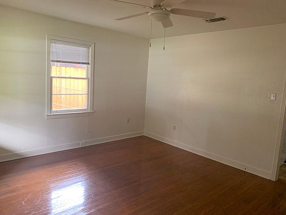 Living room with original wood floors. Dimensions - 13'5"x14'4" - front door view