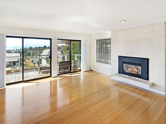 Open living area with cozy fireplace and floor to ceiling windows/doors to enjoy the view.