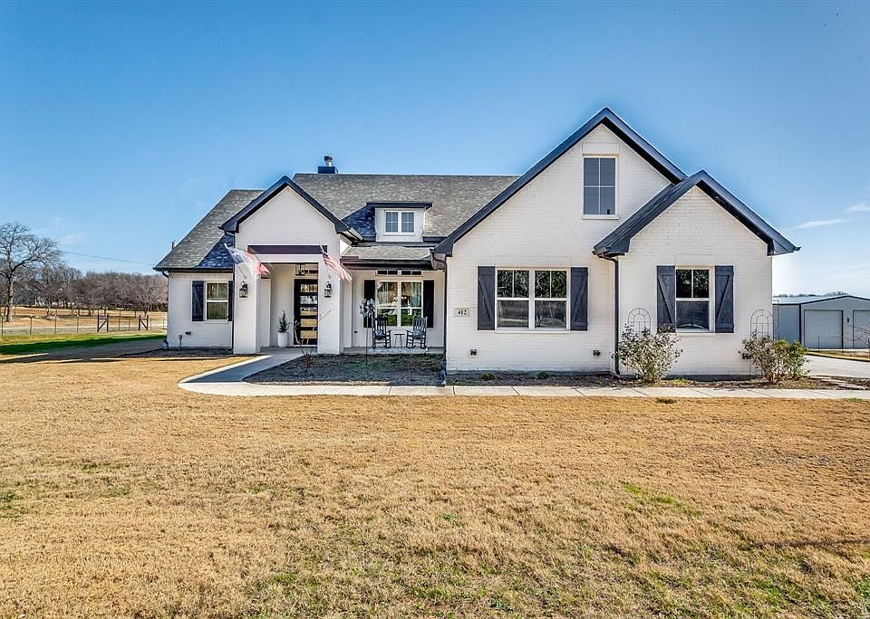 View of front of property with a porch and a front yard