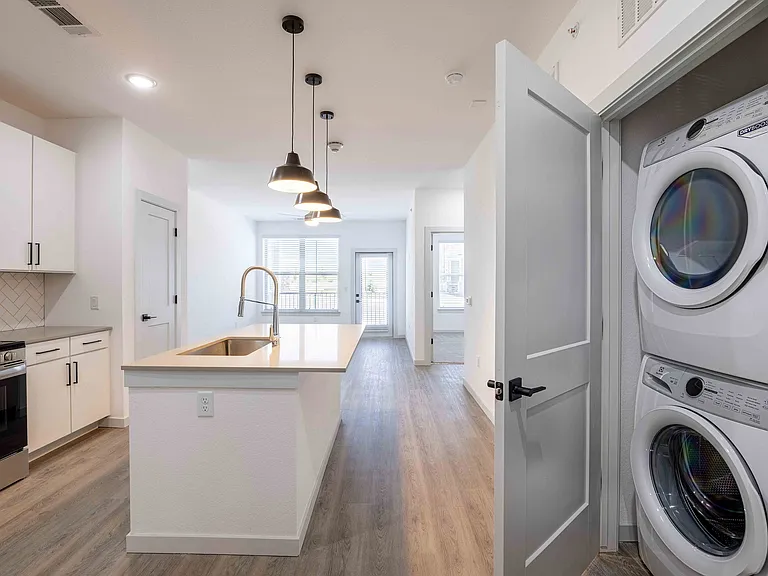 The Garrett Parker A1 floor plan includes a stacked front load washer and dryer in a closet just off the kitchen.