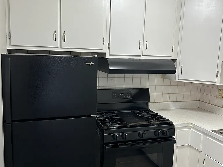 Kitchen with black appliances freshly paint kitchen cabinets & new hardware, lighting throughout