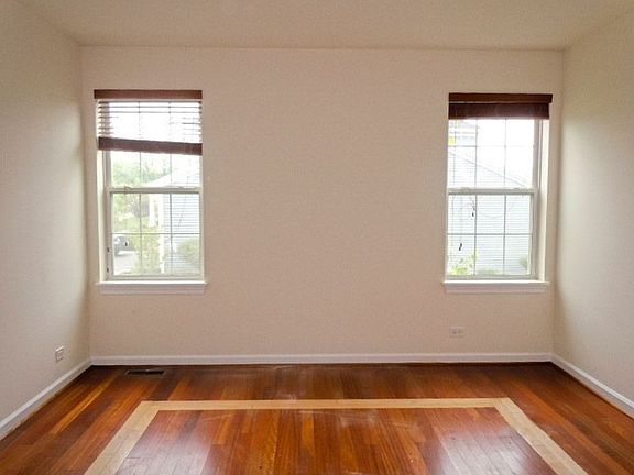Living Room w/ Panned Windows and Elegant Wood Flooring wi/ Lighter Wood Inlay