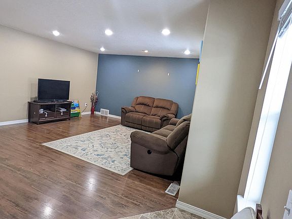 Living room with laminate flooring and recess lighting
