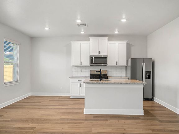 The gorgeous kitchen has beautiful white wood cabinetry.