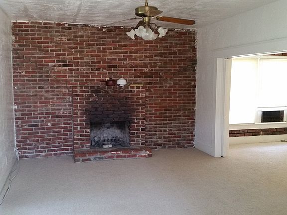 Large living room with fireplace and large ceiling fan. Coat Closet at front door. Large window facing street. Sliding doors to dining area