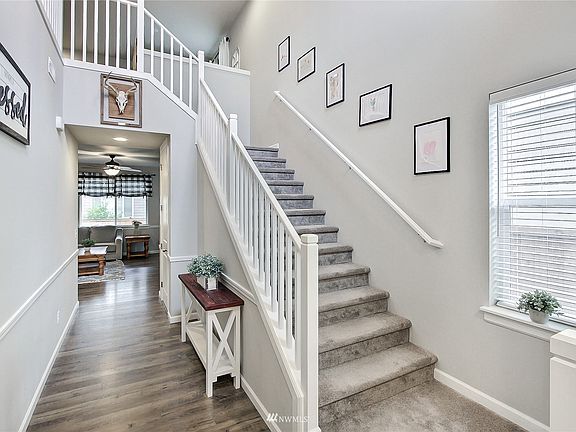 View from entry, beautiful open staircase leading up to your large loft space, 2-story foyer with beautiful flooring leading to back of home. >