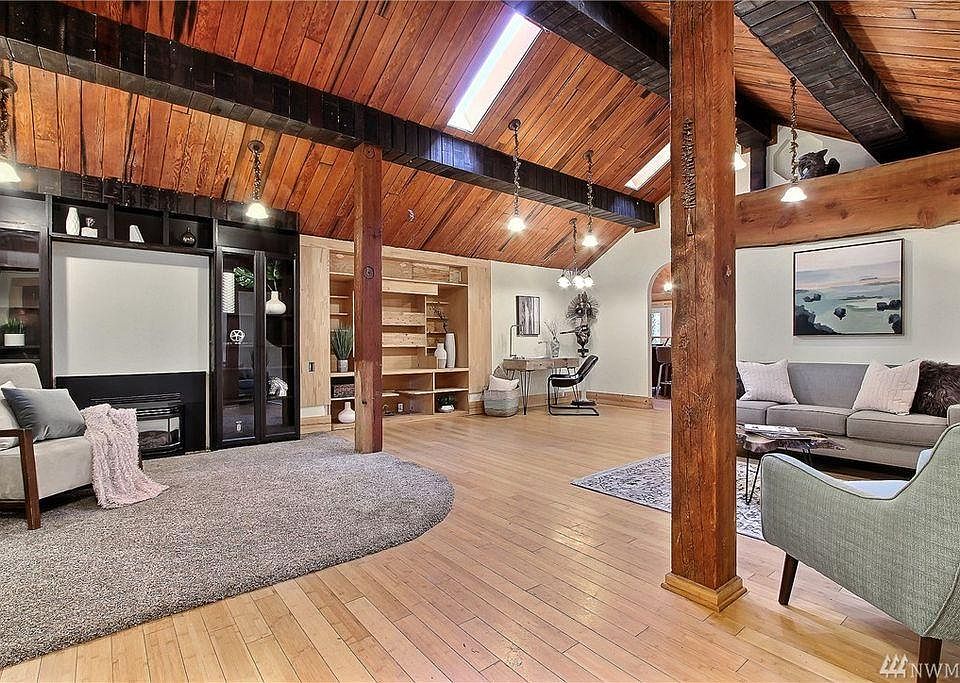 Living room with gas fireplace, skylights, bamboo floors, an