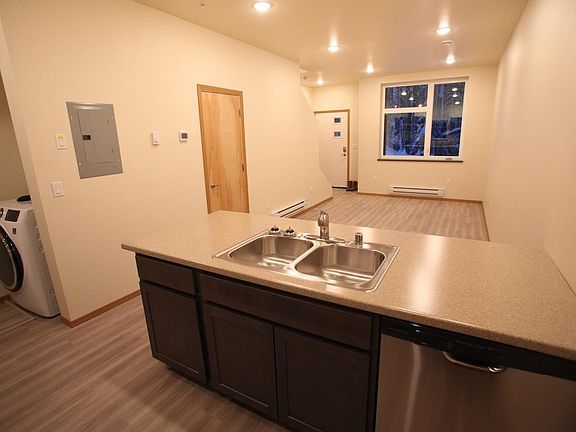 Kitchen looking towards the living room and front door, the 1/2 bath is through the door on the left. Washer/dryer in the far left corner.