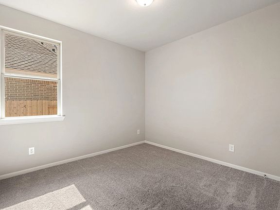 The third bedroom features plush carpet, fresh paint, closet, and a large window that lets in plenty