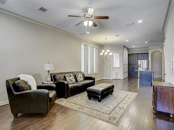 The living room is open to both the dining room and kitchen. The door in back by the kitchen leads to a side porch.