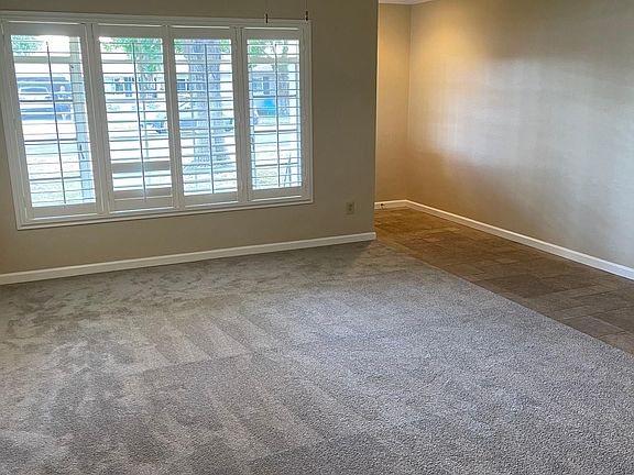 The living room is spacious and bright and newly carpeted.