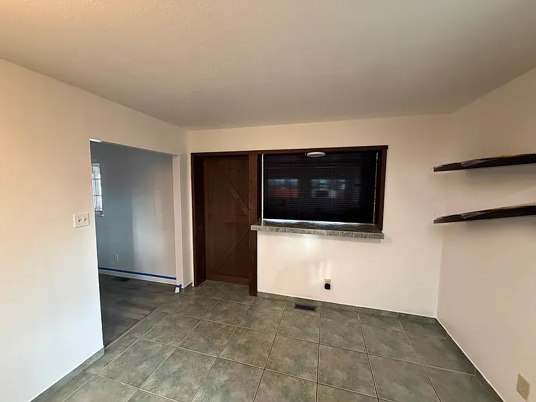 The entertainment room has a stylish sliding barnyard door and blinds to separate the kitchen for privacy.