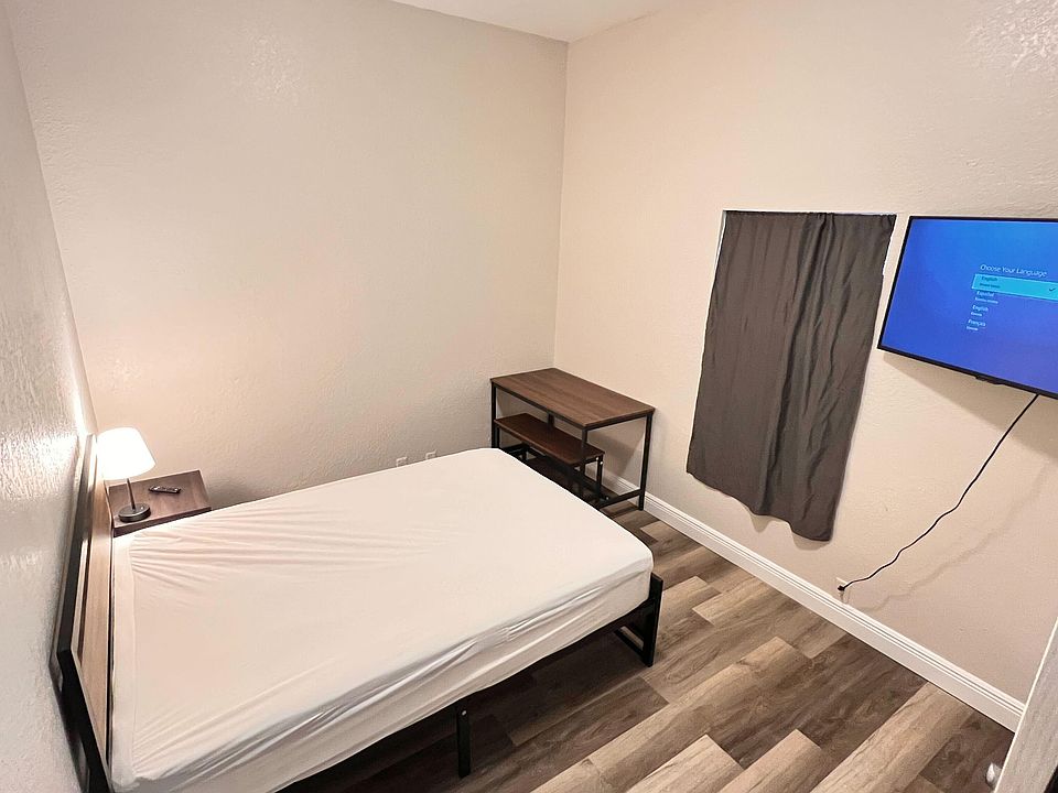 Furnished room near entrance and common area with work desk and relaxing space. Shared bath and on-site parking available.