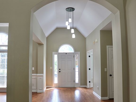 Front door and vaulted ceiling foyer.