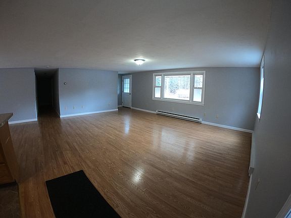 Home entrance to spacious open living room with hardwood engineered flooring