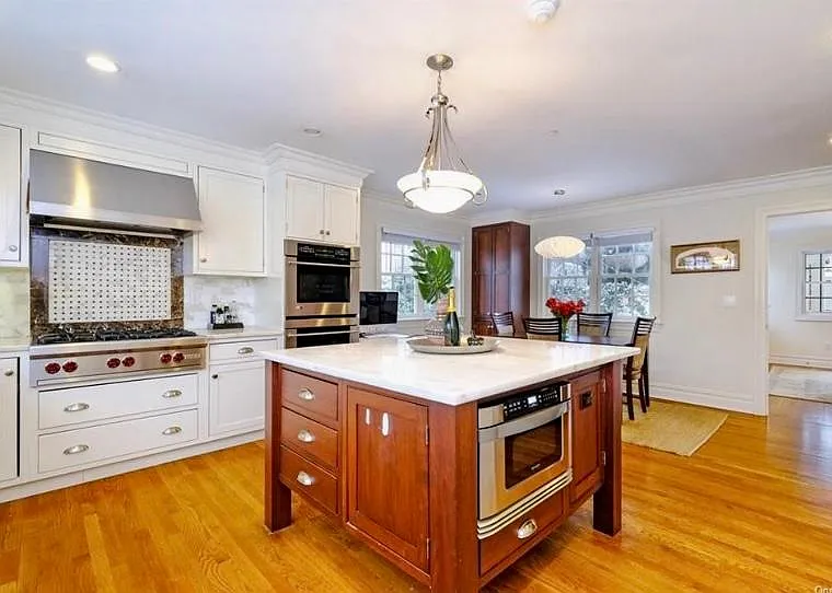 Mosaic backsplash; Wolf stovetop, GE Monogram standard and convection wall ovens, marble top center island with GE drawer microwave. Wine/crystal cabinet built in (not visible in photo).