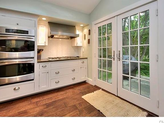 Double ovens, gas cooktop, stainless steel vent hood. French doors lead to bluestone patio