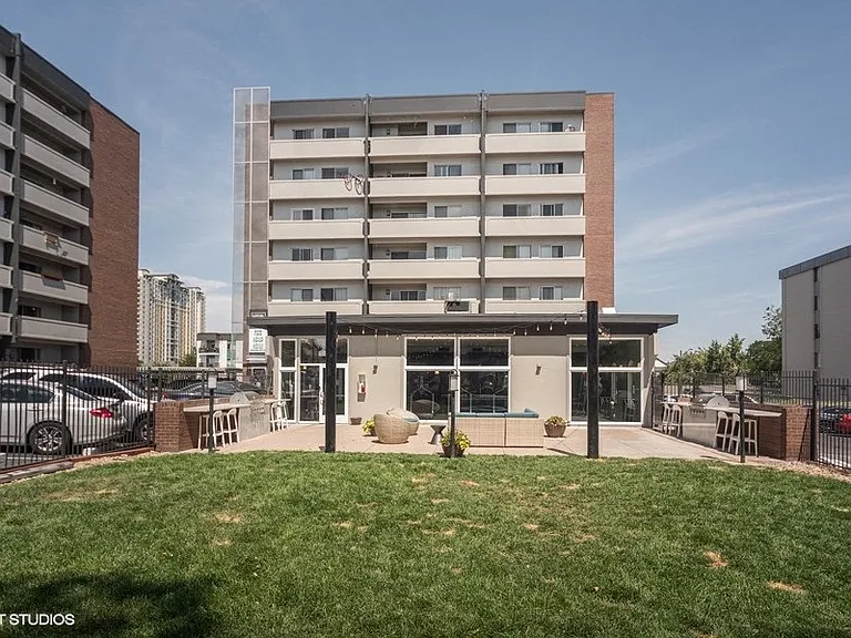 Front view with grassy area and inviting building entrance