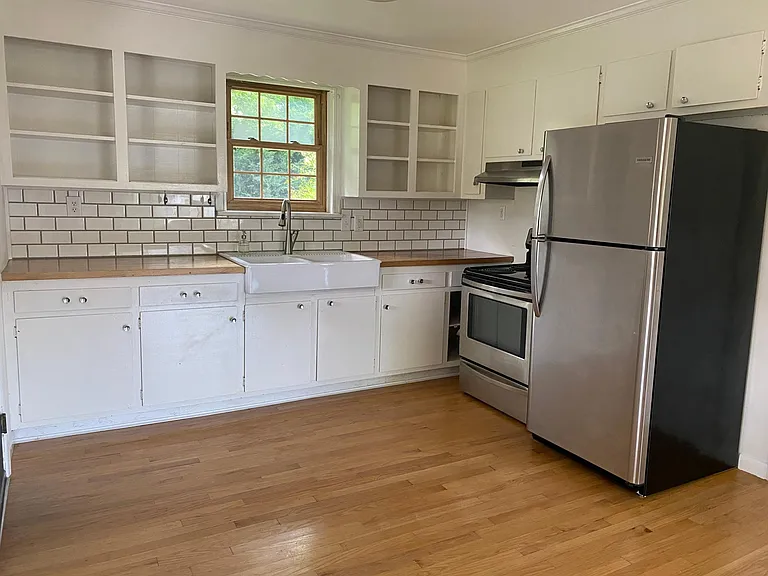 Farmhouse sink with butcher block countertops, stainless steel electric stove and frigidaire refrigerator