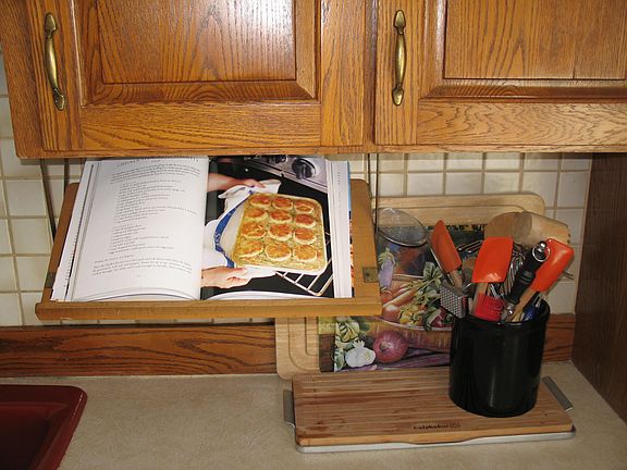 Drop down cook book holder
