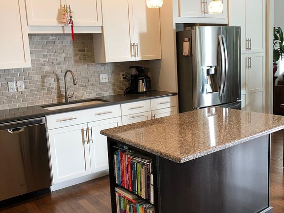Kitchen with trash/recycling bins, soft-close cabinets and pull-out drawers.