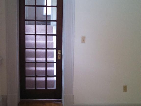 Door at base of short flight of stairs to bedroom.