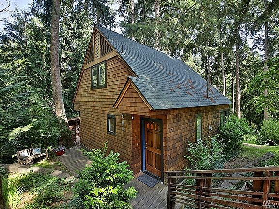 View of the north & east side of the home. Stairs to the right lead to the studio and the driveway.  Roof replaced in 2018. 