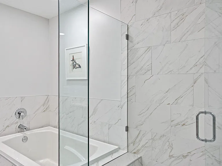 Polished Bathroom With Porcelain Tile Backsplash And Bathtub