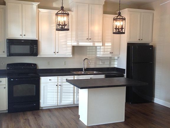 Kitchen area with island and stone counters.