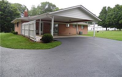 Back Ext view showing nice asphalt drive with extra parking and double carport that can be easily enclosed.