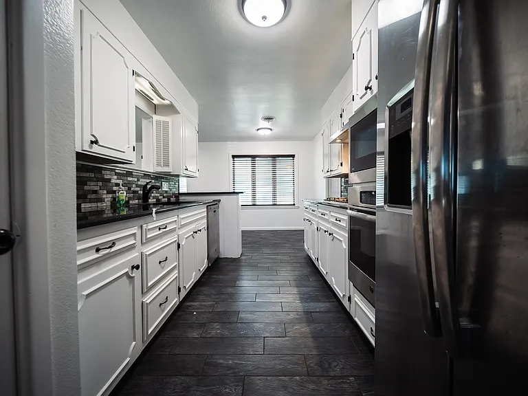 Modern kitchen with white cabinetry, ample counter space, and updated appliances