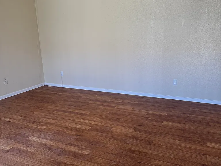 Living area with freshly painted walls, updated fan and stunning faux-wood flooring.