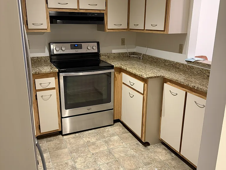 View of the kitchen upon entering the condo. Plenty of storage, beautiful countertops, view into the living room.